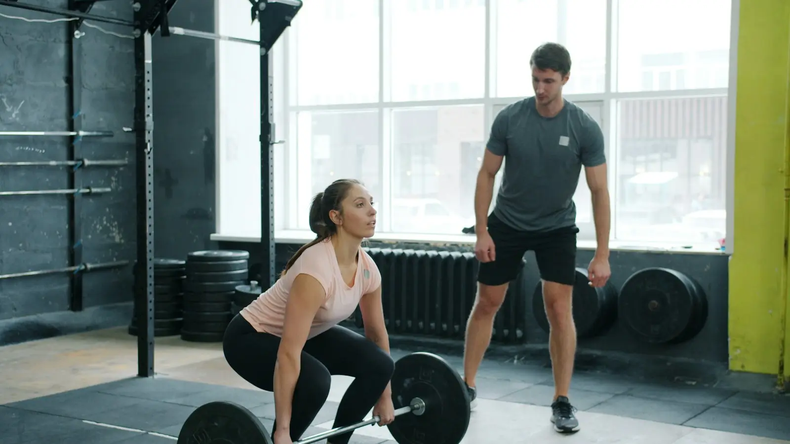 Trenér sleduje techniku mrtvého tahu u klientky v boxu